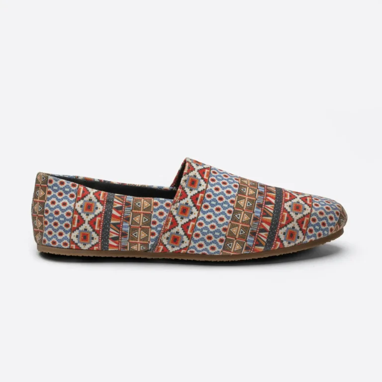 Side profile of a SWAVE slip-on shoe in a red and blue woven pattern. E-commerce shoe photography for SWAVE by MRPS in Dubai.