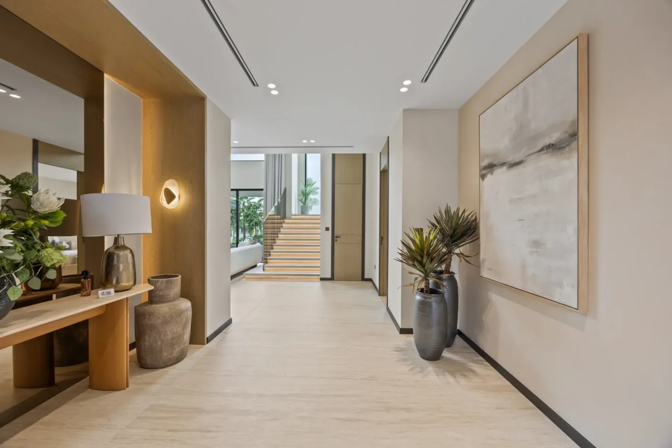 Entrance hallway with a console table, wall art and the staircase beyond, luxury villa in Jumeirah Islands, Dubai.