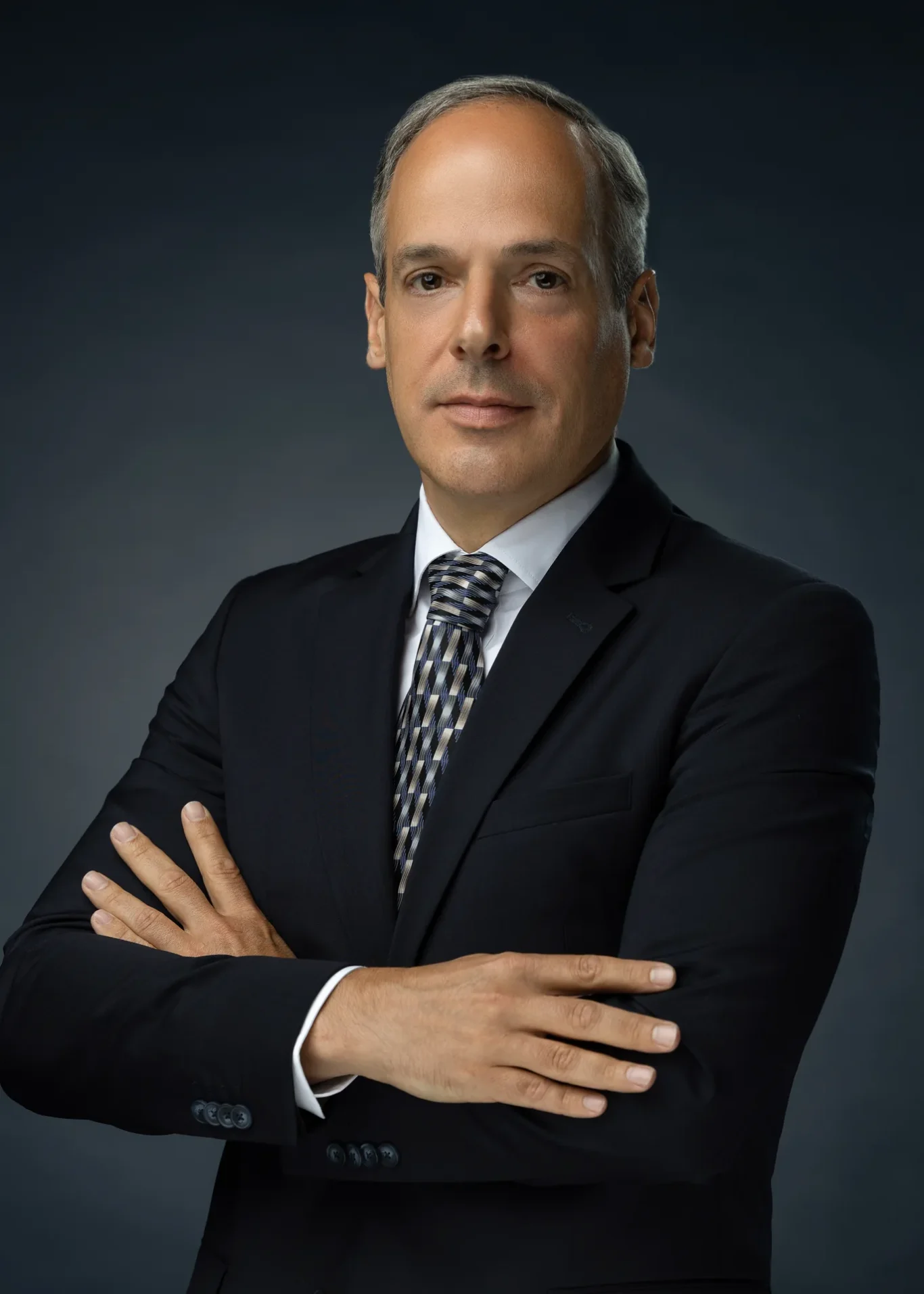 Half-body leadership portrait with arms crossed and a confident smile. Corporate business portrait of a Dubai CEO, photographed at the MRPS studio in Business Bay.