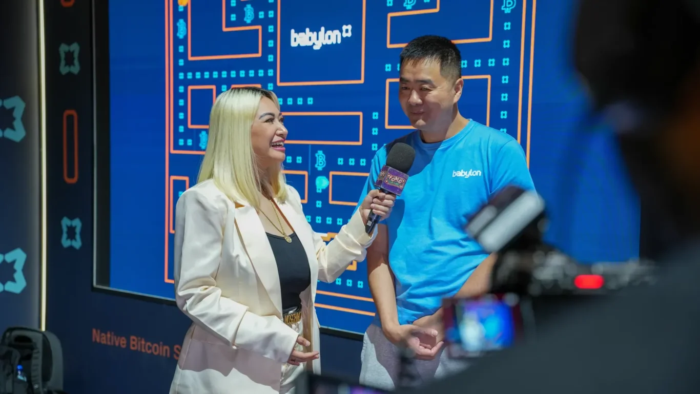 On-camera interview with a Babylon team member at the booth. Photographed by MRPS for Eventflare at Binance Blockchain Week 2025, Coca-Cola Arena, Dubai.