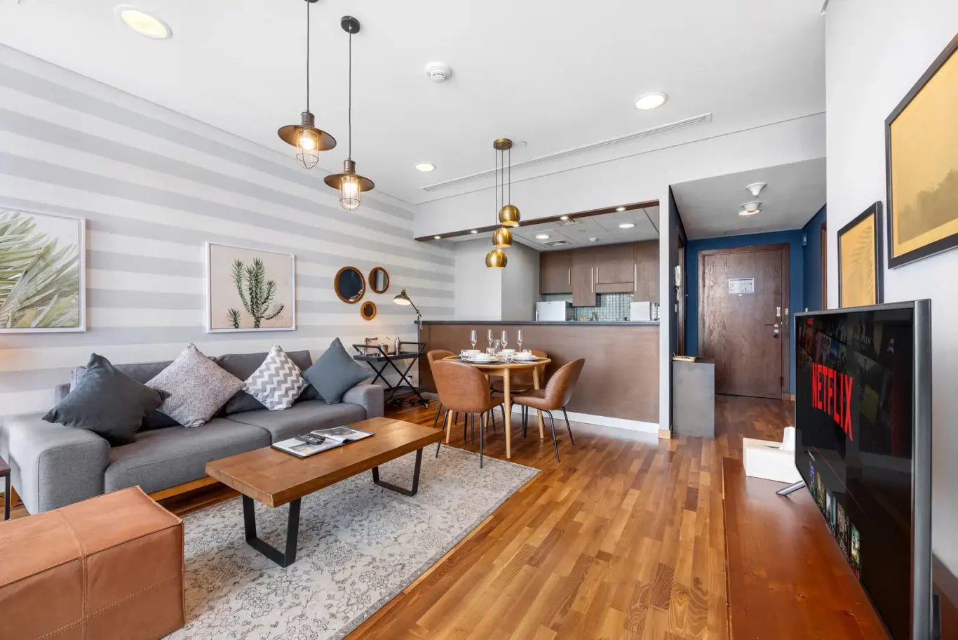 Open plan living and dining area with pendant lights in a Your Stay Apartments one-bedroom at Burj Daman, DIFC, Dubai.