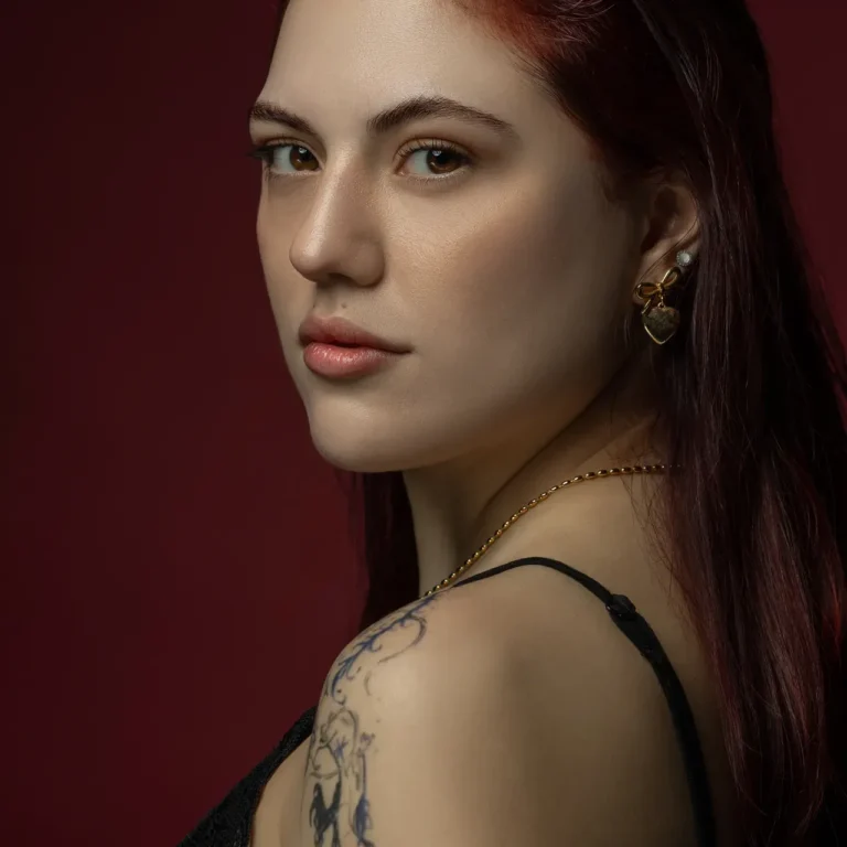 Over-the-shoulder gaze with gold earrings and soft side light. Beauty portrait of model Julian, photographed by Nastaran at the MRPS studio in Dubai.