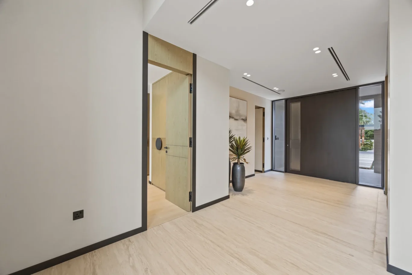 Entrance hall with the front door and light stone flooring, luxury villa in Jumeirah Islands, Dubai.