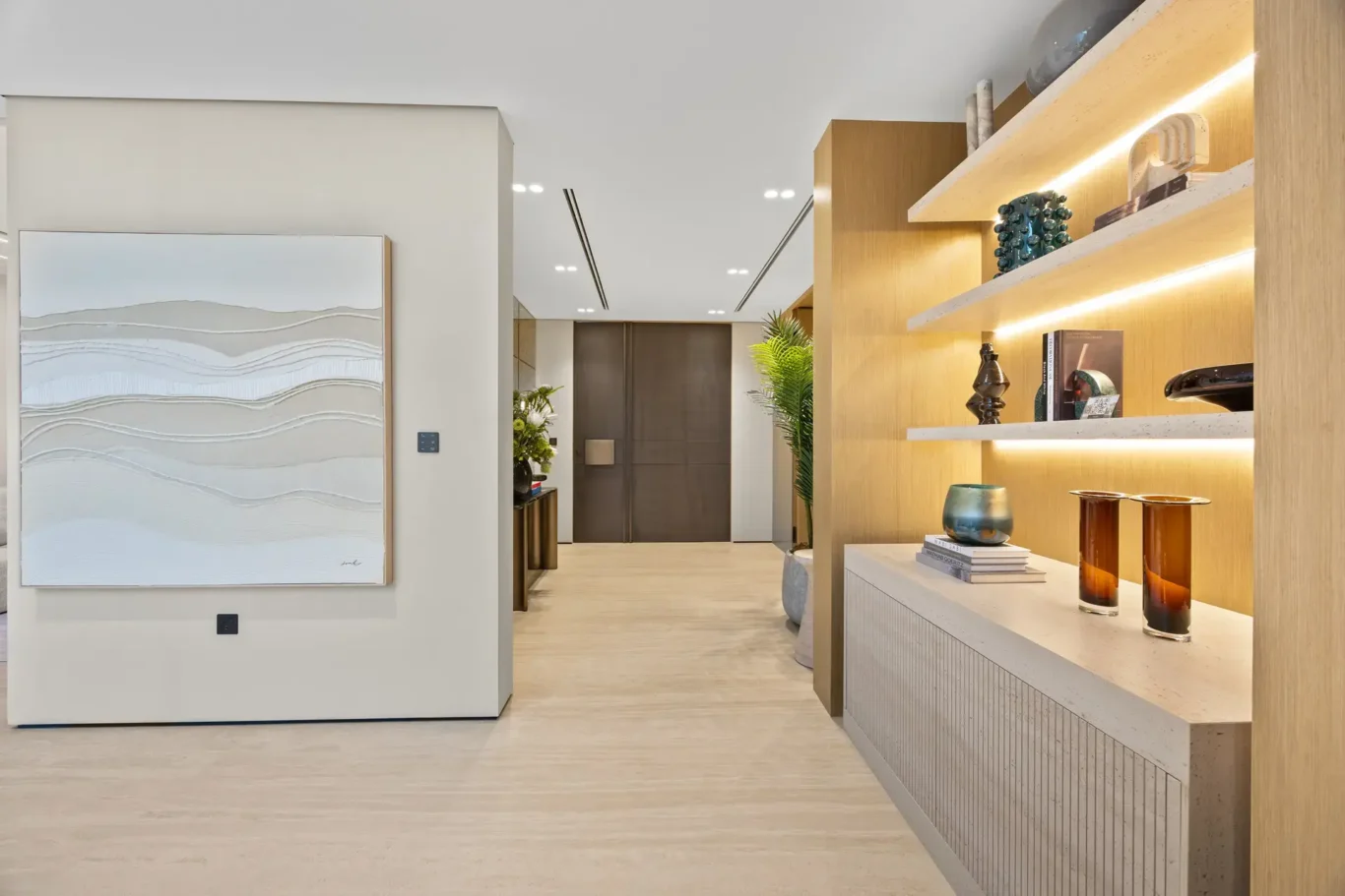 Entrance hallway with artwork and lit display shelves, luxury villa in Jumeirah Islands, Dubai.
