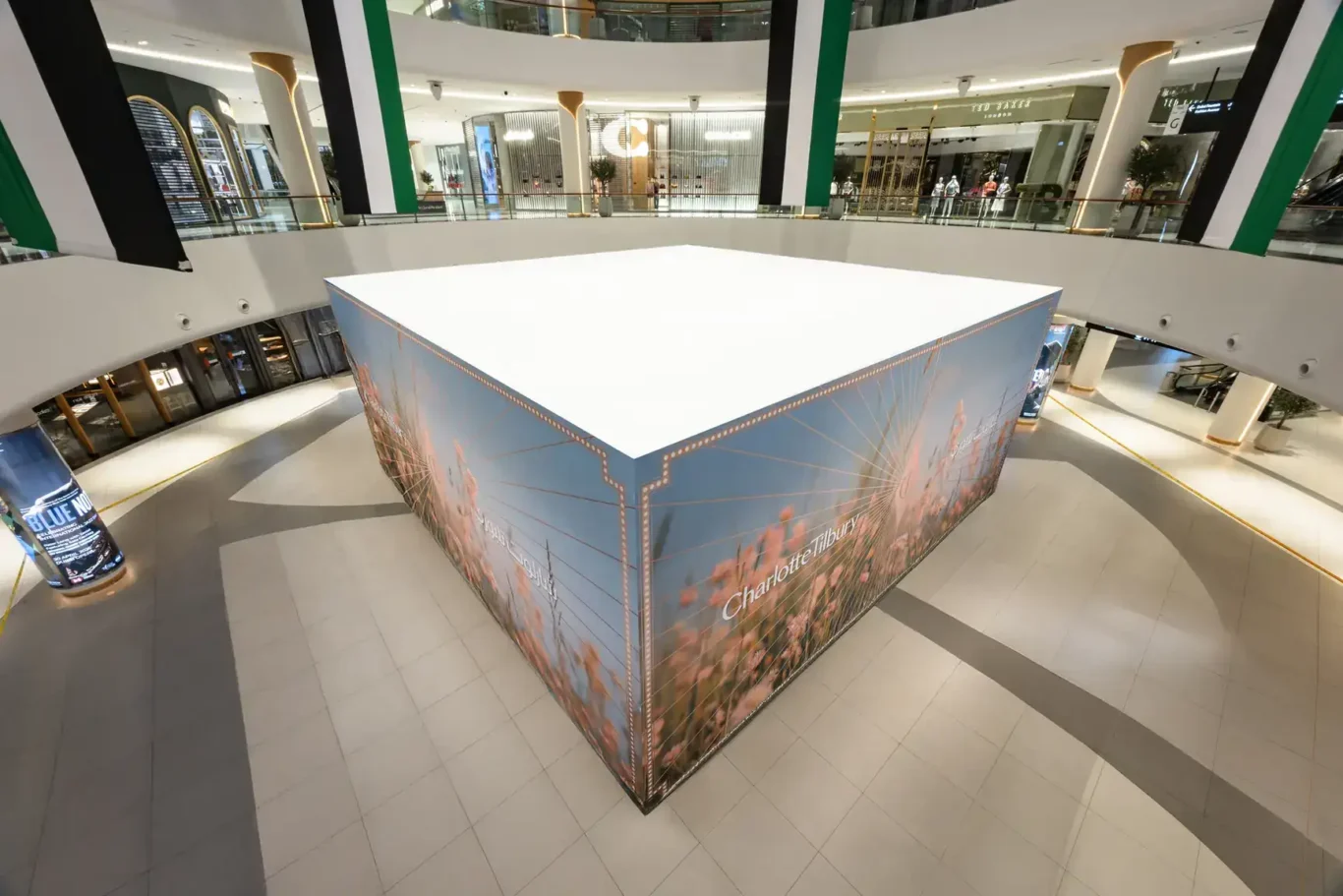 High-angle view of the enclosed freestanding Hoarding by Lomax structure with printed graphics on the mall floor at The Dubai Mall.