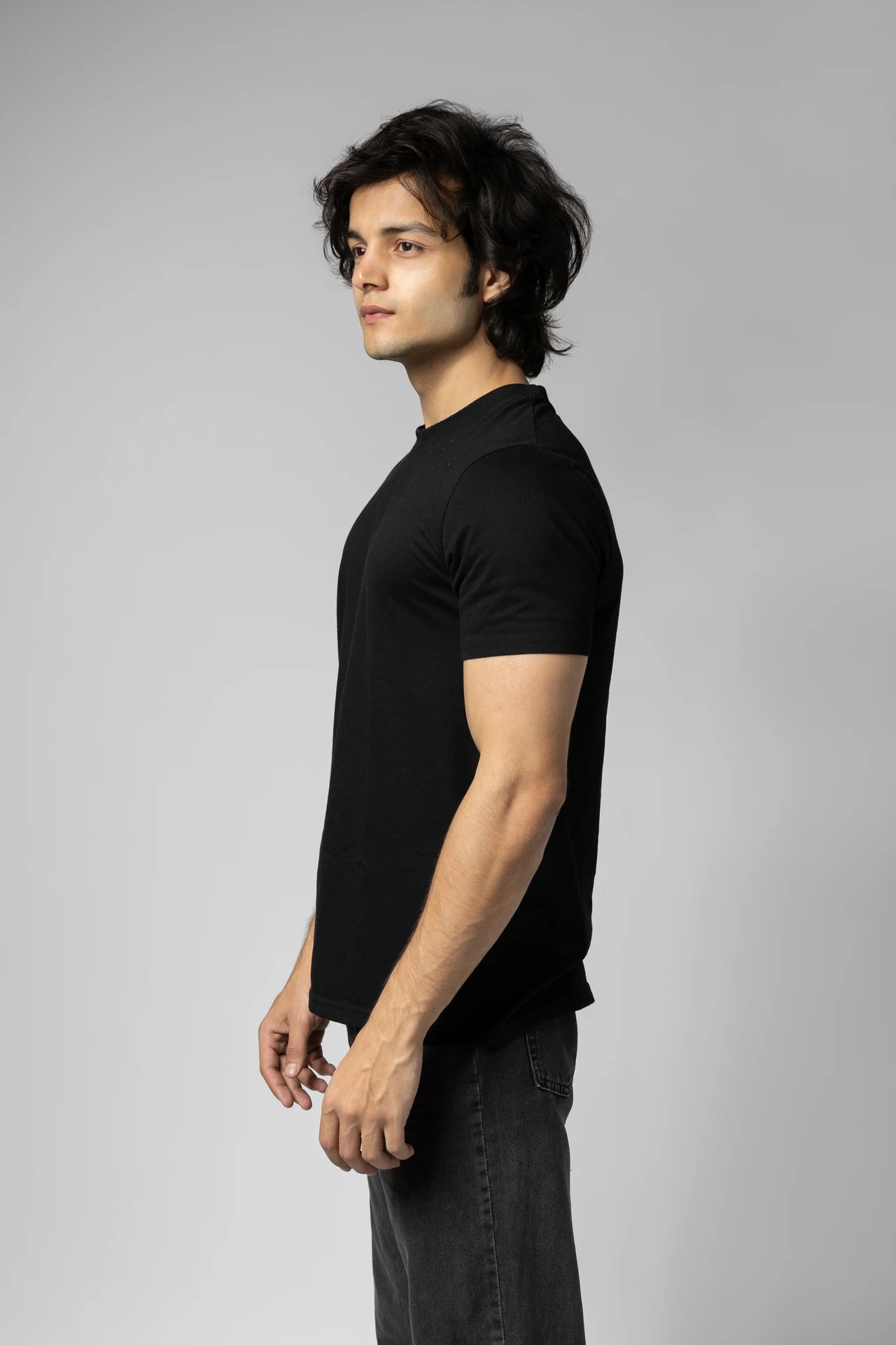 Three-quarter profile digital of Arsh in a black t-shirt, looking away from the camera.