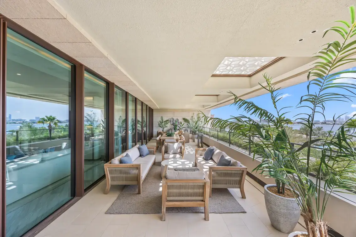 Terrace dining and seating area along the glass facade in a furnished three-bedroom residence at Atlantis The Royal, Palm Jumeirah, photographed for Apex Homes Real Estate.