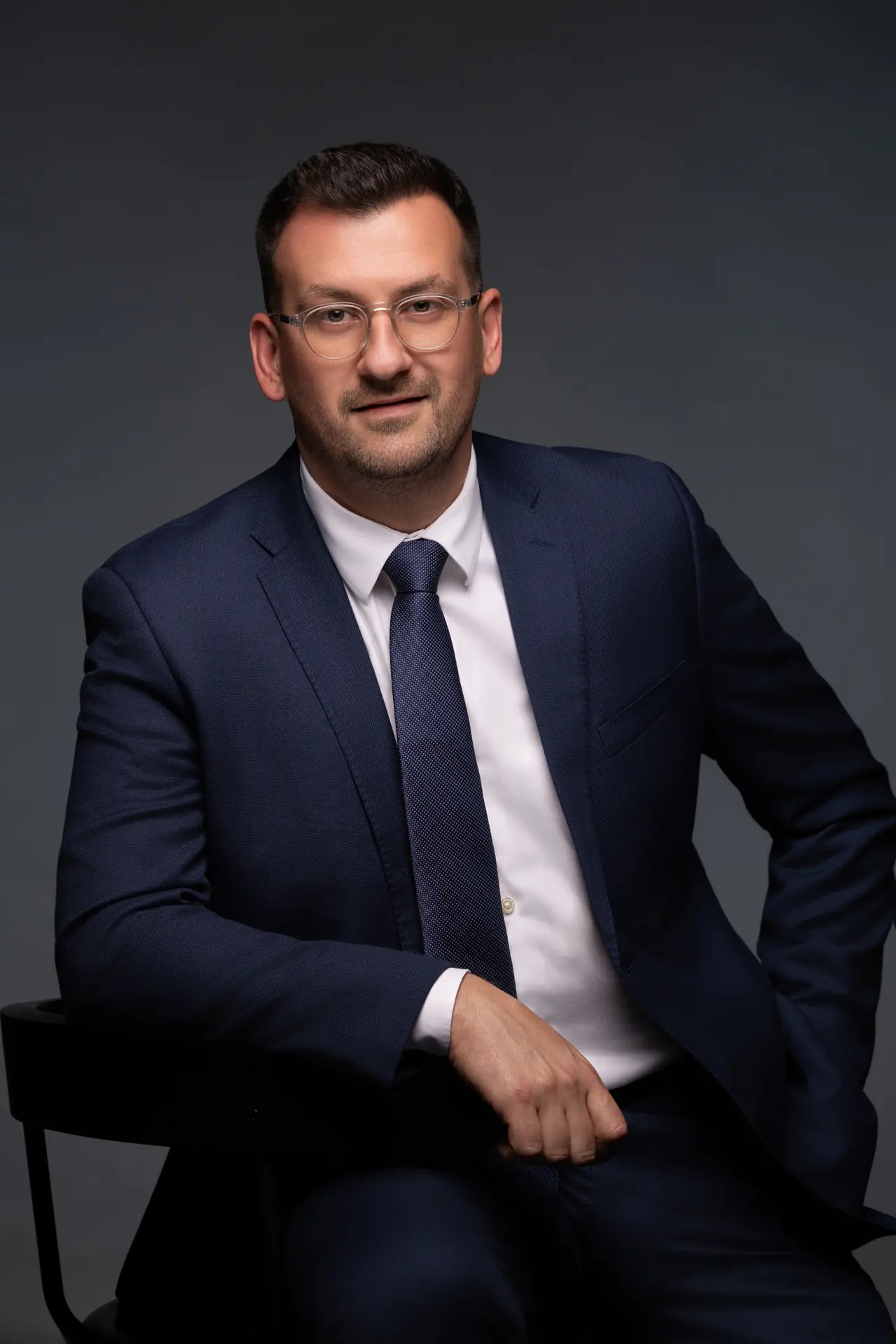 Seated CEO portrait leaning forward for a website About page. Photographed at the MRPS studio in Business Bay, Dubai.