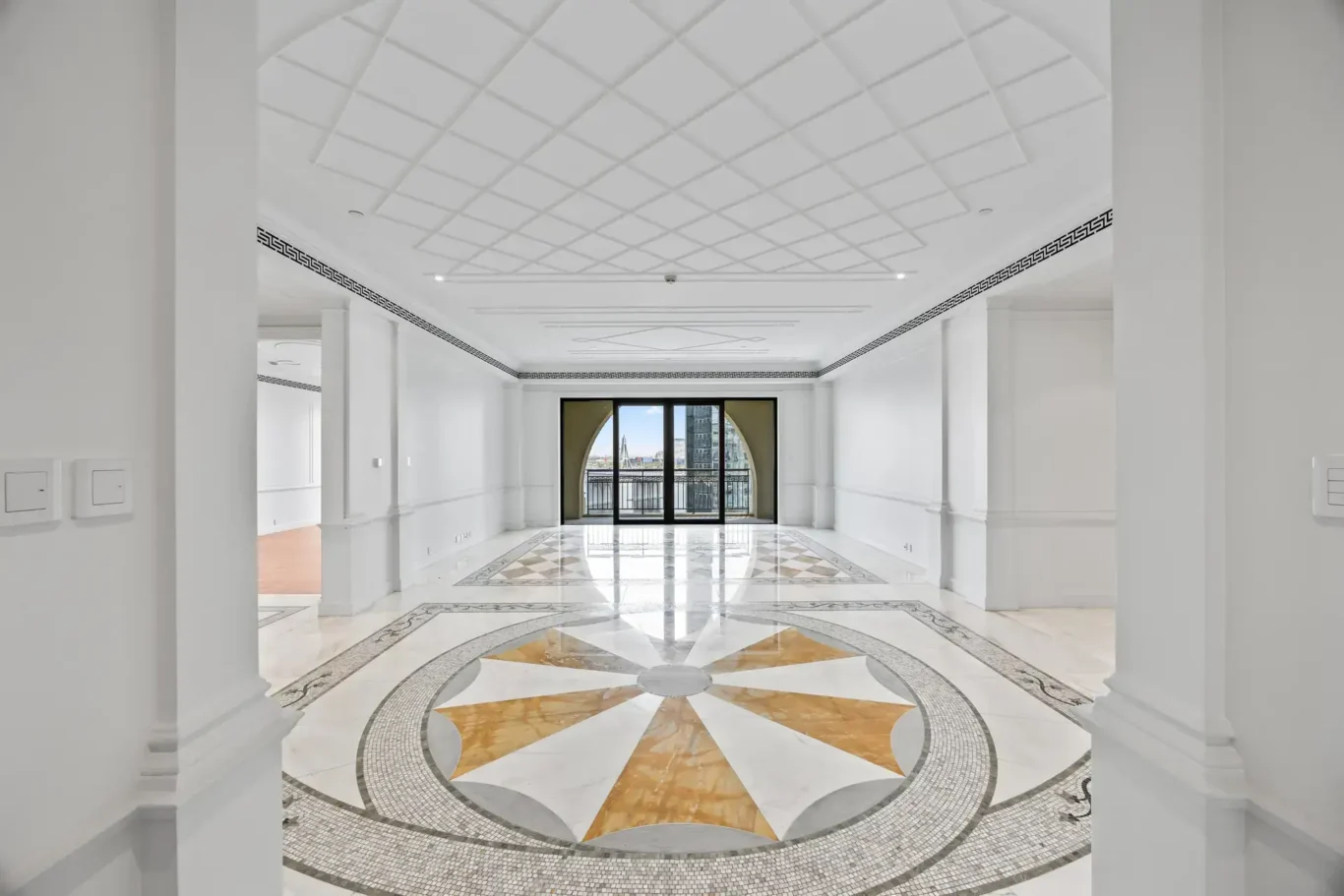 Entrance foyer with an inlaid marble star floor and arched window in a three-bedroom residence at Palazzo Versace Dubai, Jaddaf Waterfront, photographed for Concierge Auctions.