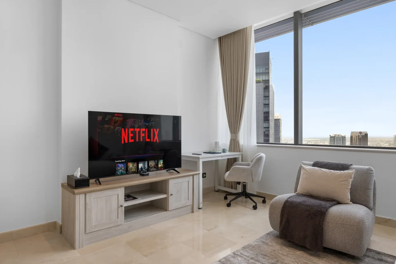 TV unit and work desk by the window in a Your Stay Apartments one-bedroom at Sky Gardens, DIFC, Dubai.