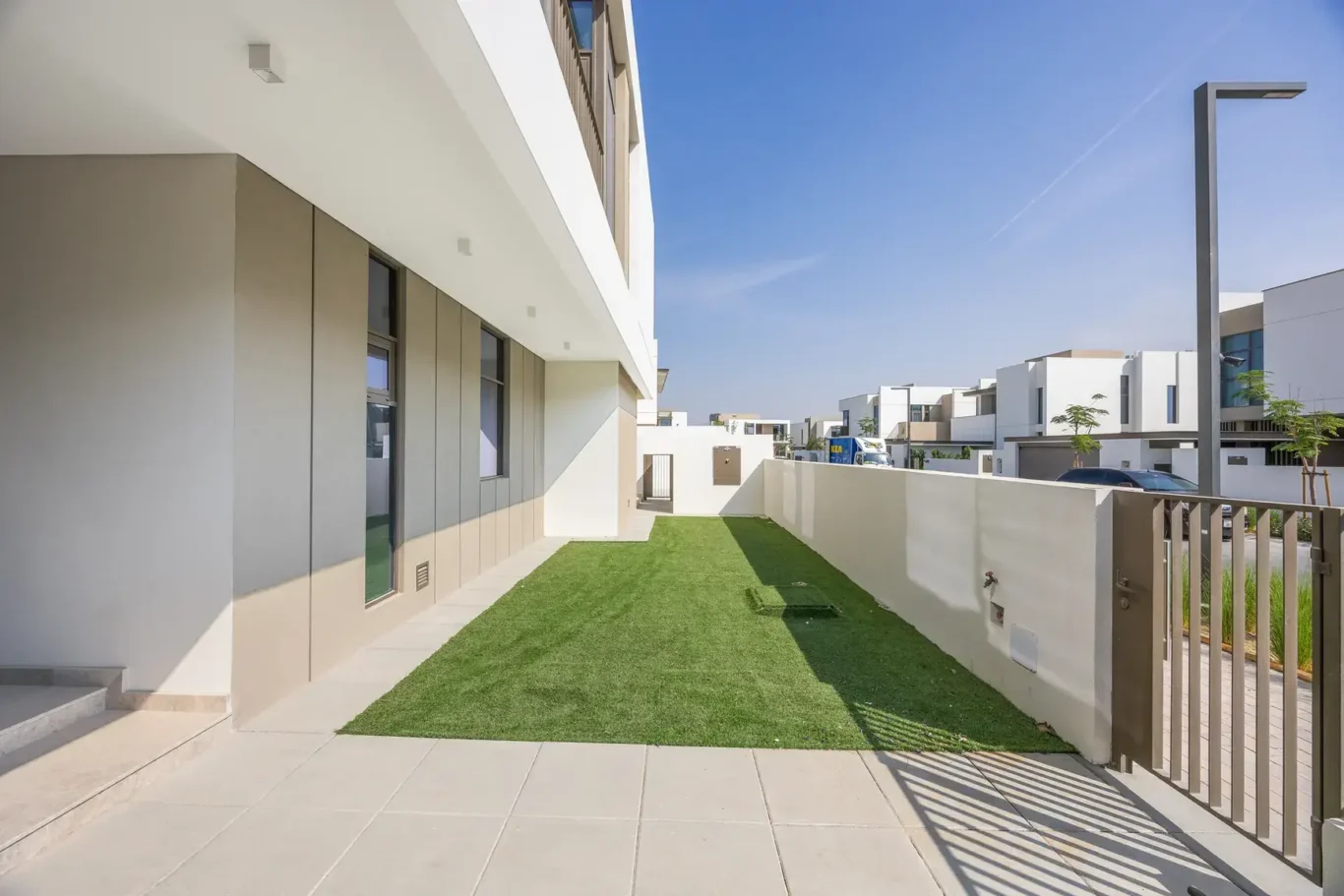 Private garden with lawn and patio beside the villa. Villa photography by MRPS in Dubai for ELITE Property Brokerage.