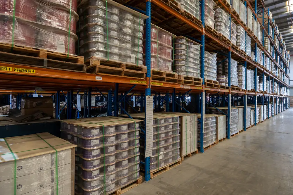 Long racking aisle with pallets of B3 International cable reels on several levels, Jebel Ali, Dubai.