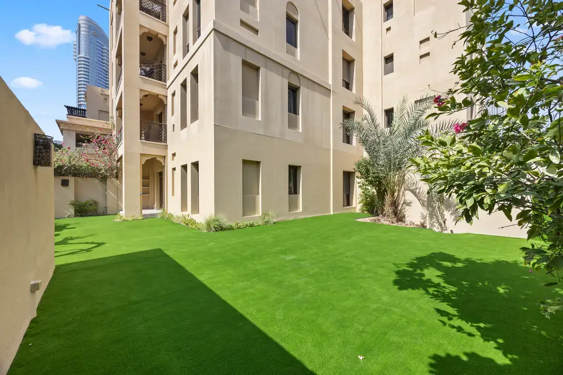 Garden surrounded by Arabian-style Old Town buildings in an unfurnished two-bedroom garden apartment in Old Town, Downtown Dubai, photographed for ELITE Property Brokerage.