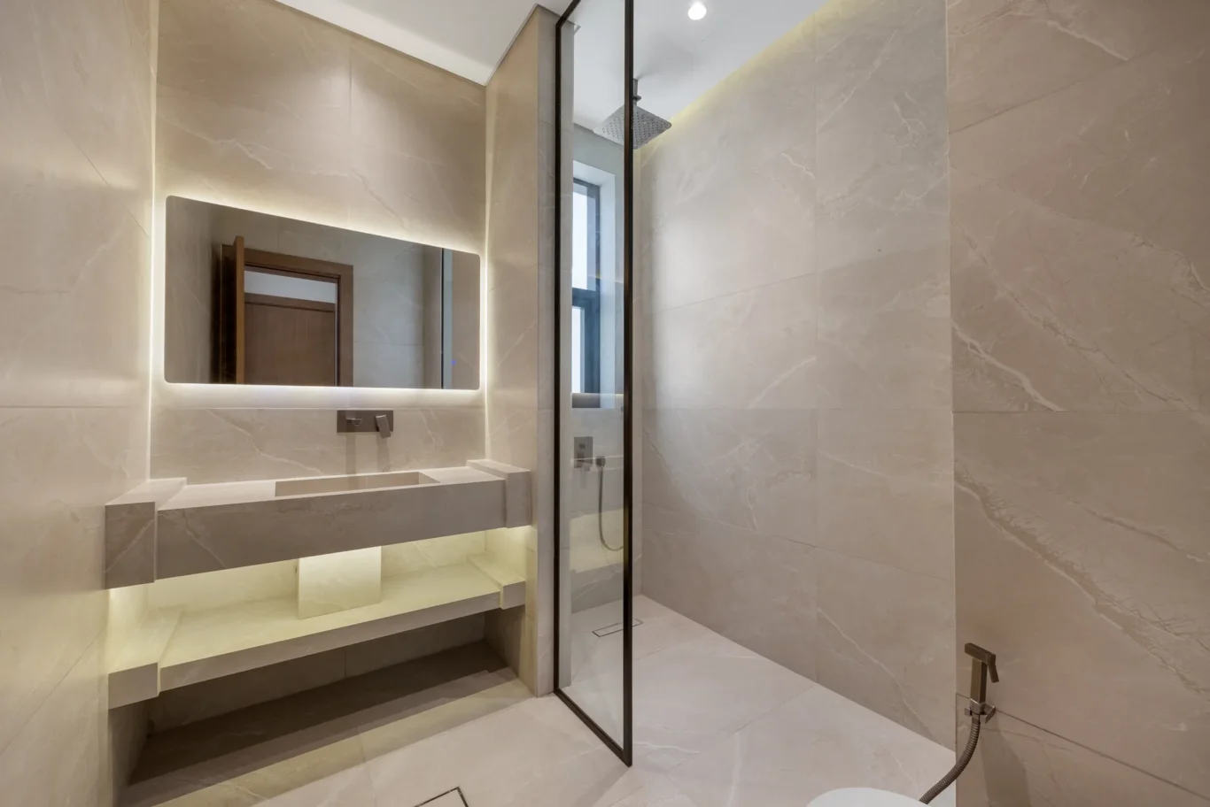 En-suite bathroom with a backlit mirror and walk-in shower, unfurnished five-bedroom villa in Al Furjan, Dubai.