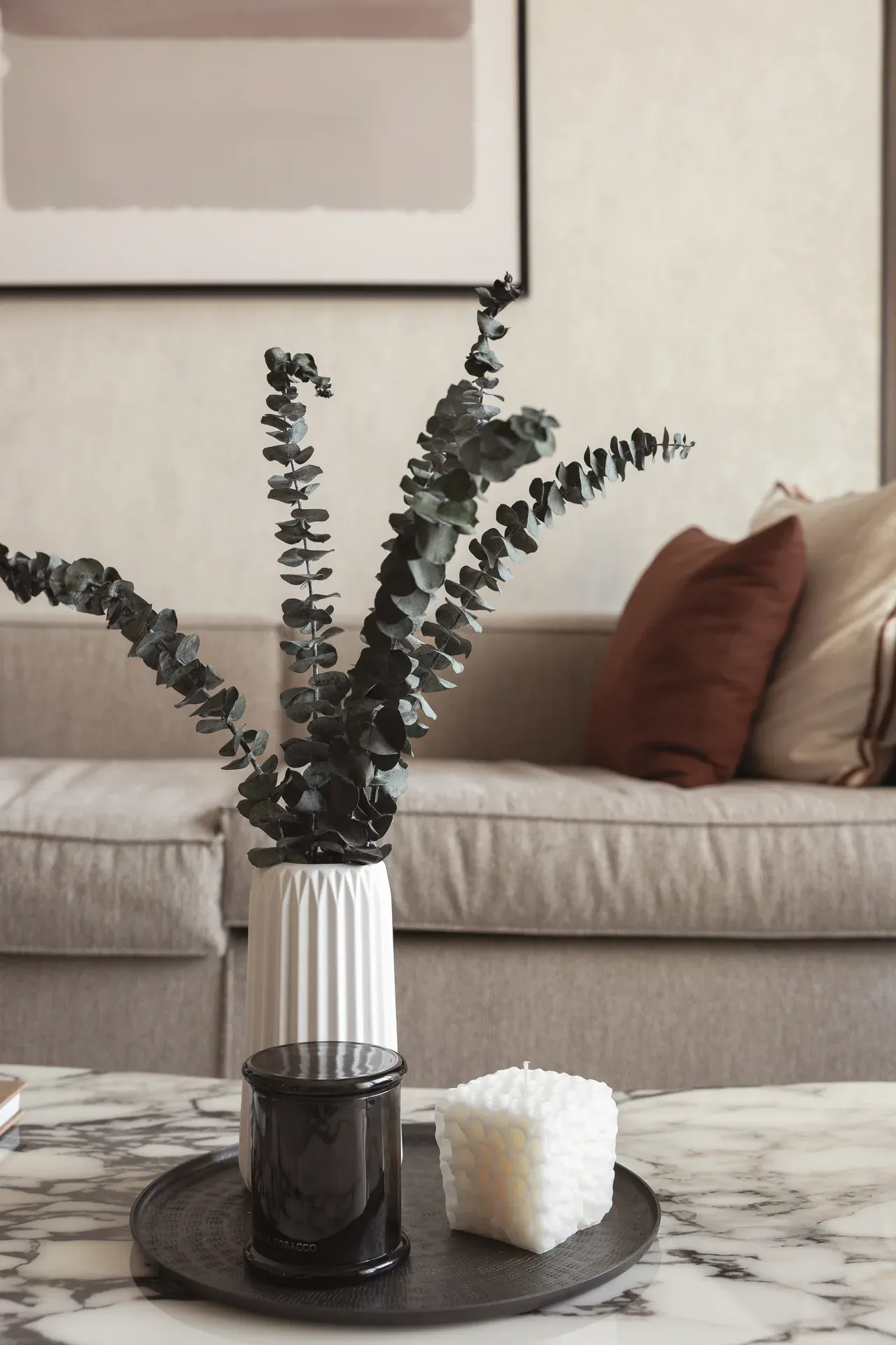 Coffee table styling with eucalyptus, ribbed vase and candle on a black tray. Interior design photography for Aziza Home by MRPS in Dubai.