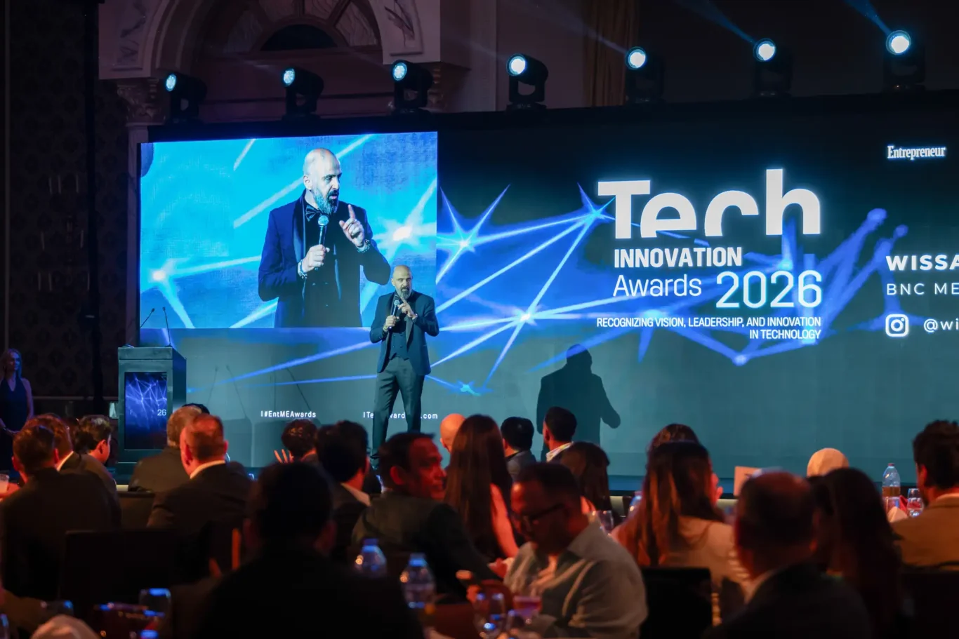 Speaker on stage with the Tech Innovation Awards 2026 screen behind. Event photography by MRPS for FundedNext at the Tech Innovation Awards 2026, Al Habtoor Palace, Dubai.