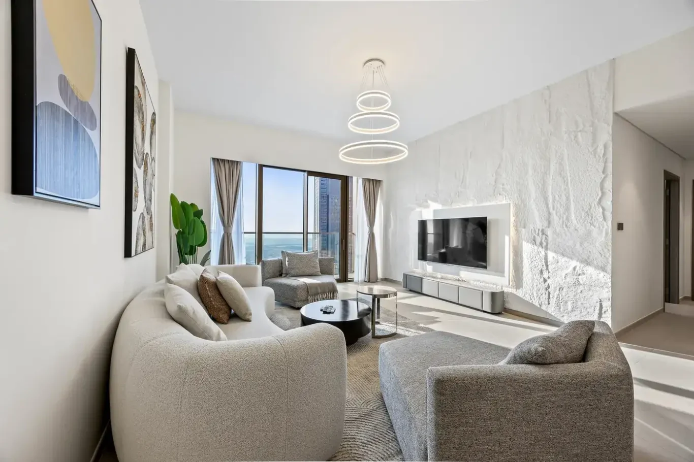 Living room corner by the window with abstract art and soft seating. Airbnb photography by MRPS for Solea Stay in Dubai.