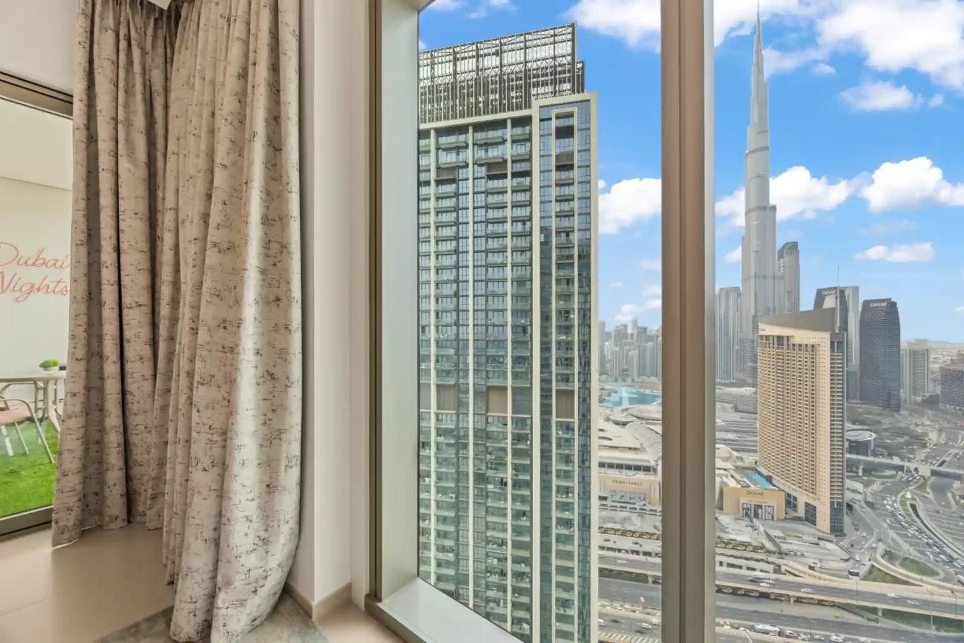 Living room window with Downtown Dubai towers in the background. Day, twilight and night Airbnb photography by MRPS for Vista Haus Holiday Homes in Downtown Dubai.