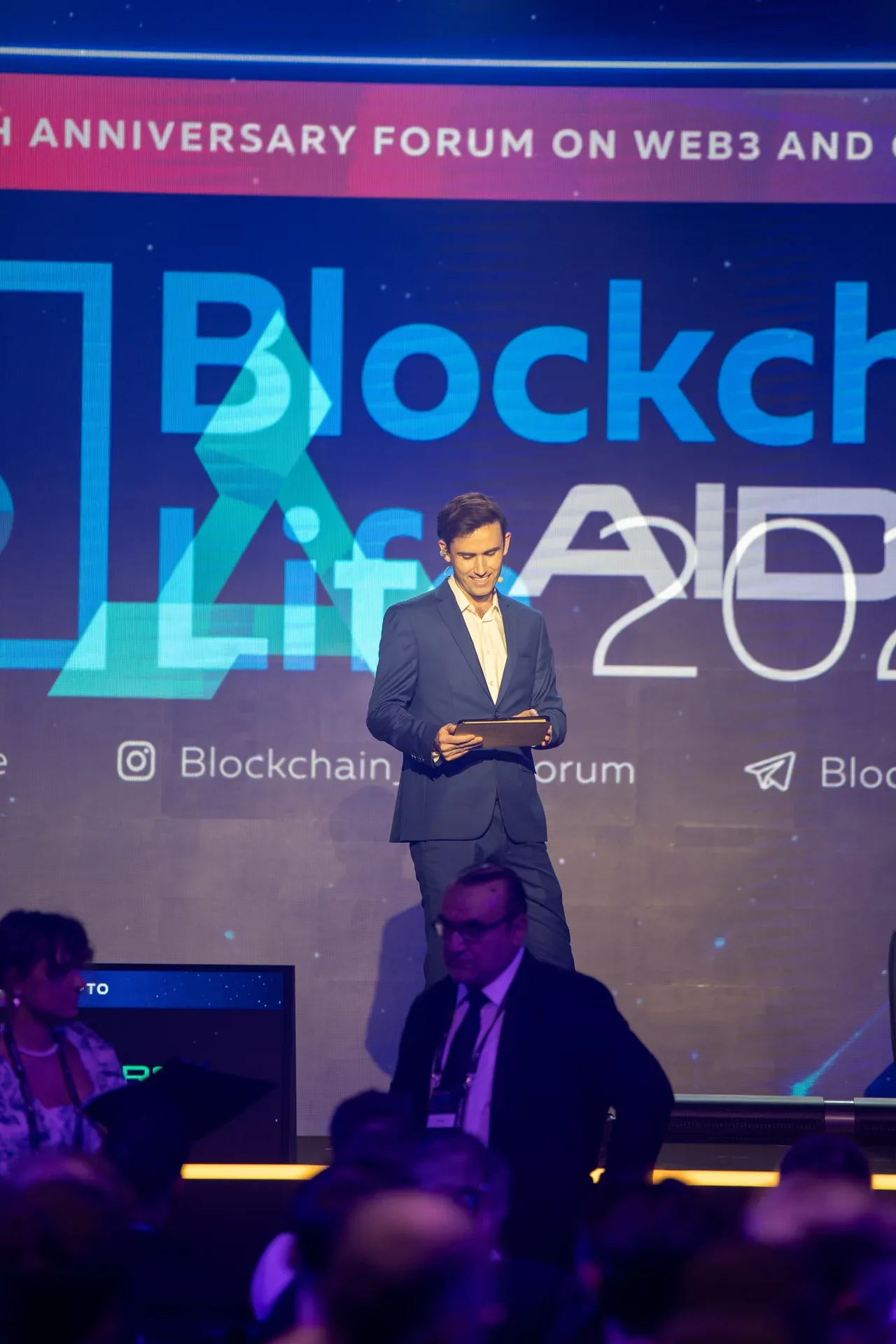 Speaker at the podium under the Blockchain Life 2025 screen. Event photography by MRPS at Blockchain Life 2025, Festival Arena, Dubai.