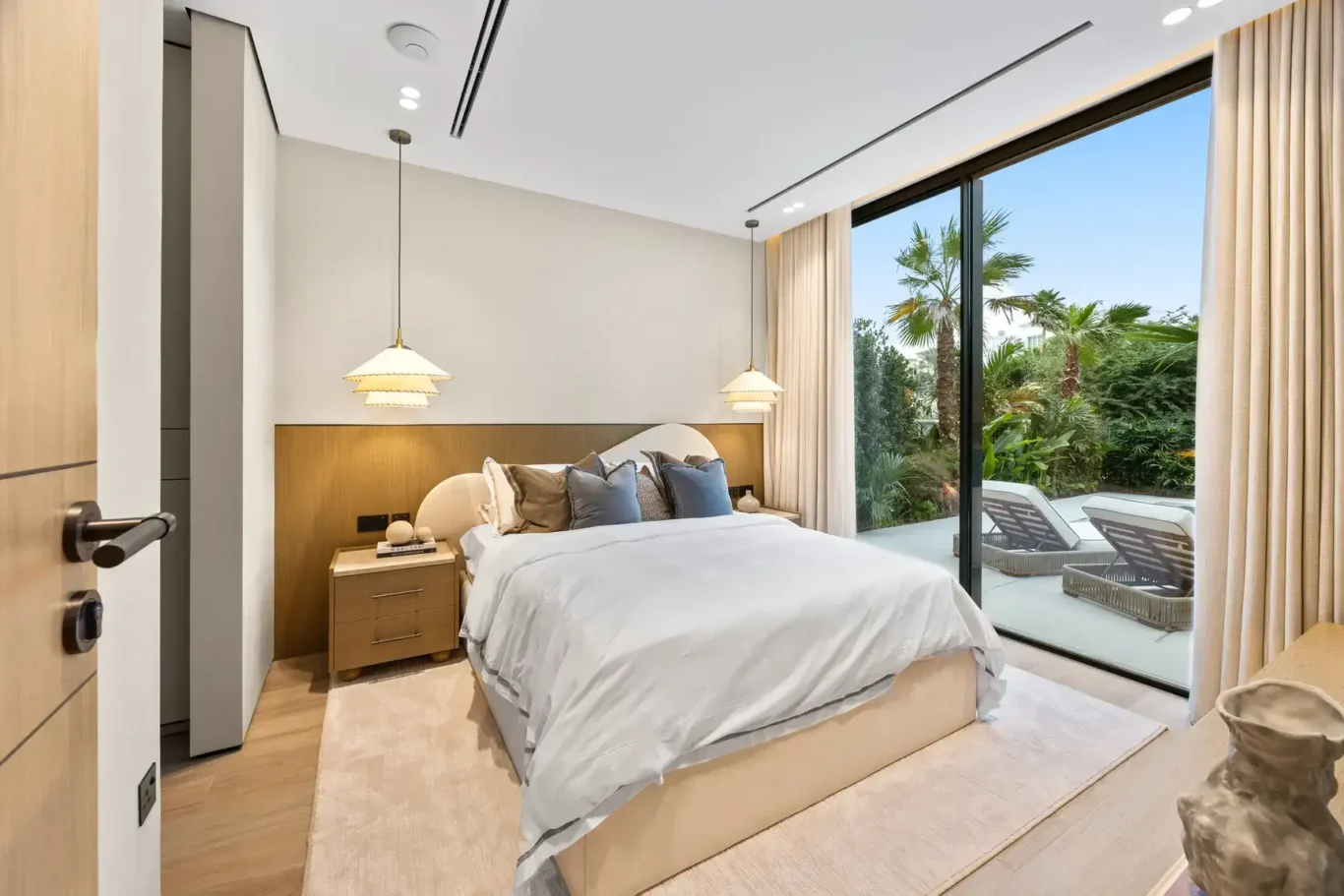 Ground floor bedroom with pendant lamps and a view of the pool, luxury villa in Jumeirah Islands, Dubai.
