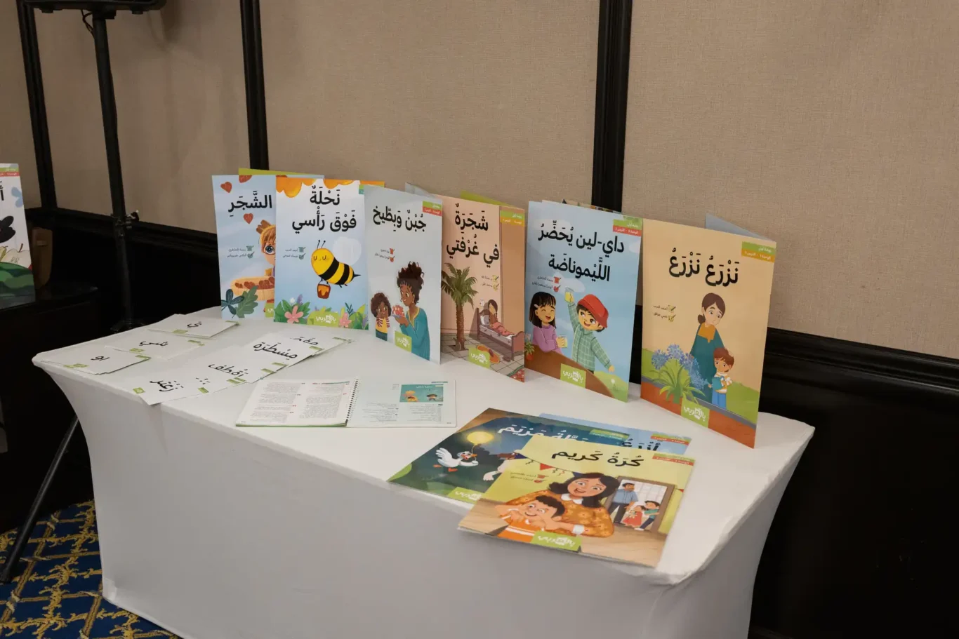 Display table of My Arabic children's Arabic books and readers at the event entrance. Corporate event photography by MRPS for My Arabic Publishing at Movenpick Grand Al Bustan, Dubai.