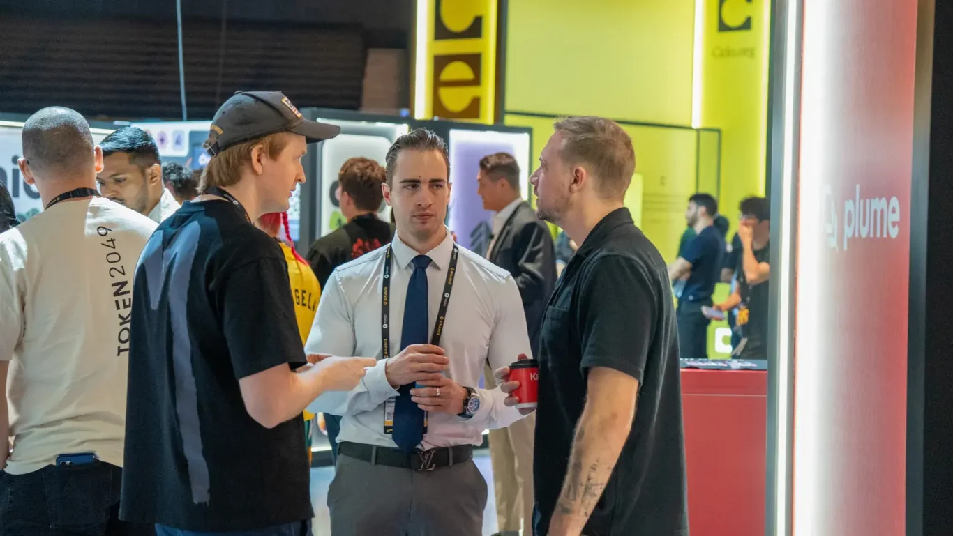 Attendees networking on the exhibition floor. Photographed by MRPS for Eventflare at Binance Blockchain Week 2025, Coca-Cola Arena, Dubai.