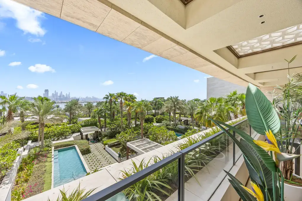 View over the landscaped gardens and pools from the terrace in a furnished three-bedroom residence at Atlantis The Royal, Palm Jumeirah, photographed for Apex Homes Real Estate.