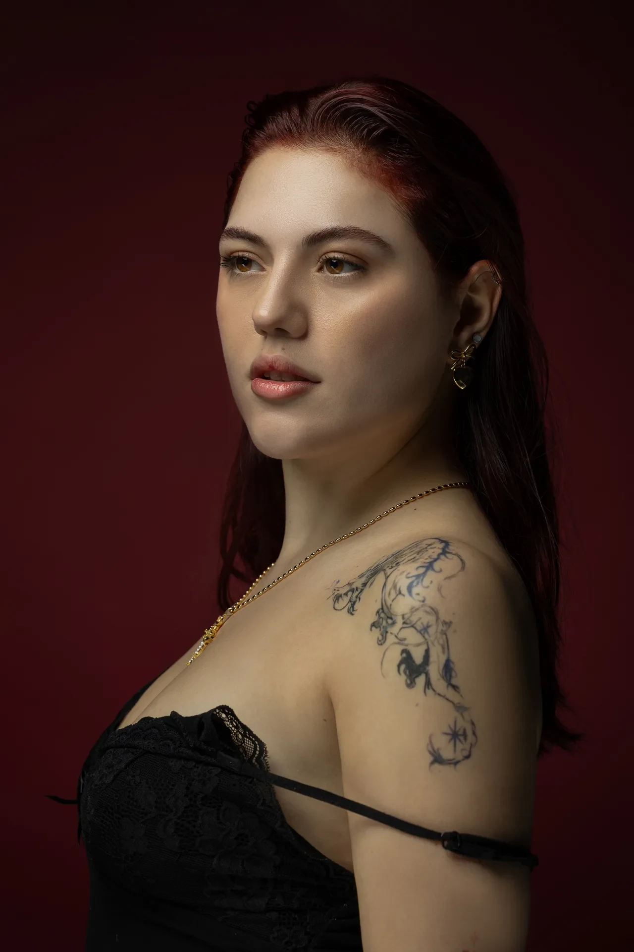Three-quarter portrait in black lace with the tattoo visible. Beauty portrait of model Julian, photographed by Nastaran at the MRPS studio in Dubai.