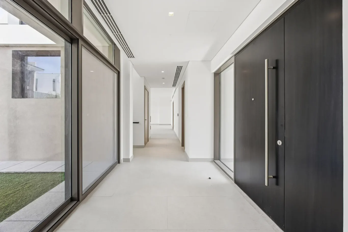 Entrance hallway with a black front door and tiled floor. Villa photography by MRPS in Dubai for ELITE Property Brokerage.