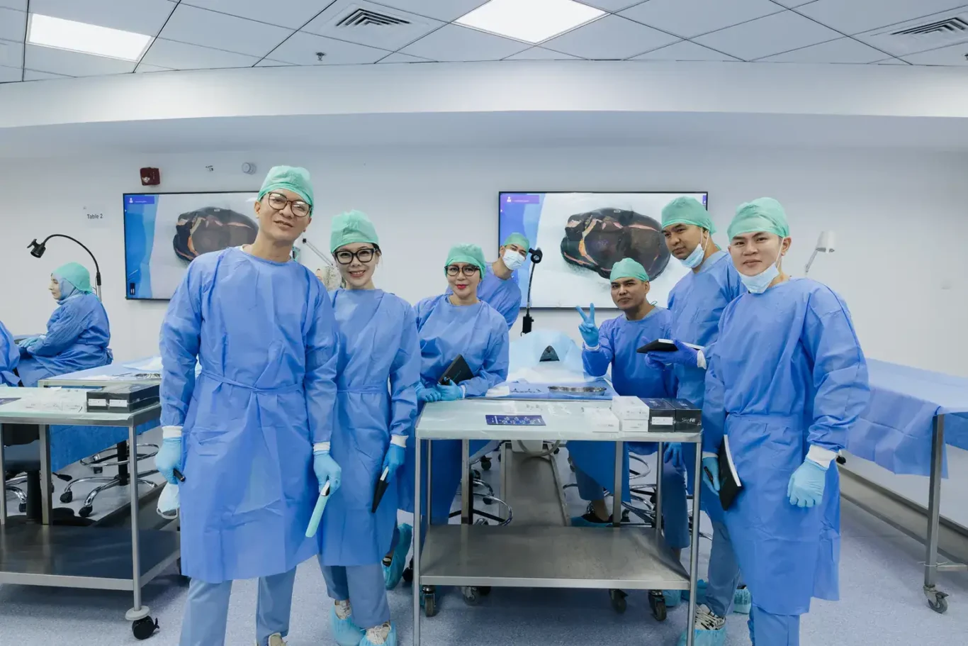 Faculty in surgical gowns and caps in the anatomy lab. Event photography by MRPS at the Promoitalia Cadaver Lab medical anatomy course in Dubai.