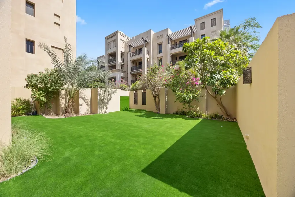 Garden corner with planting and boundary walls in an unfurnished two-bedroom garden apartment in Old Town, Downtown Dubai, photographed for ELITE Property Brokerage.