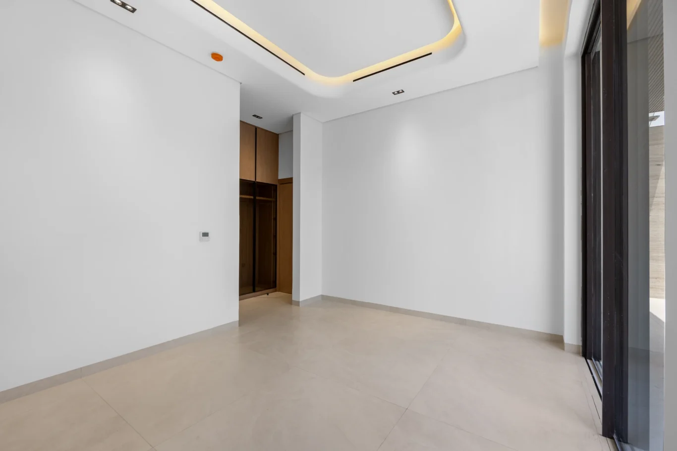 Ground floor bedroom with a built-in wardrobe and cove lighting, unfurnished five-bedroom villa in Al Furjan, Dubai.