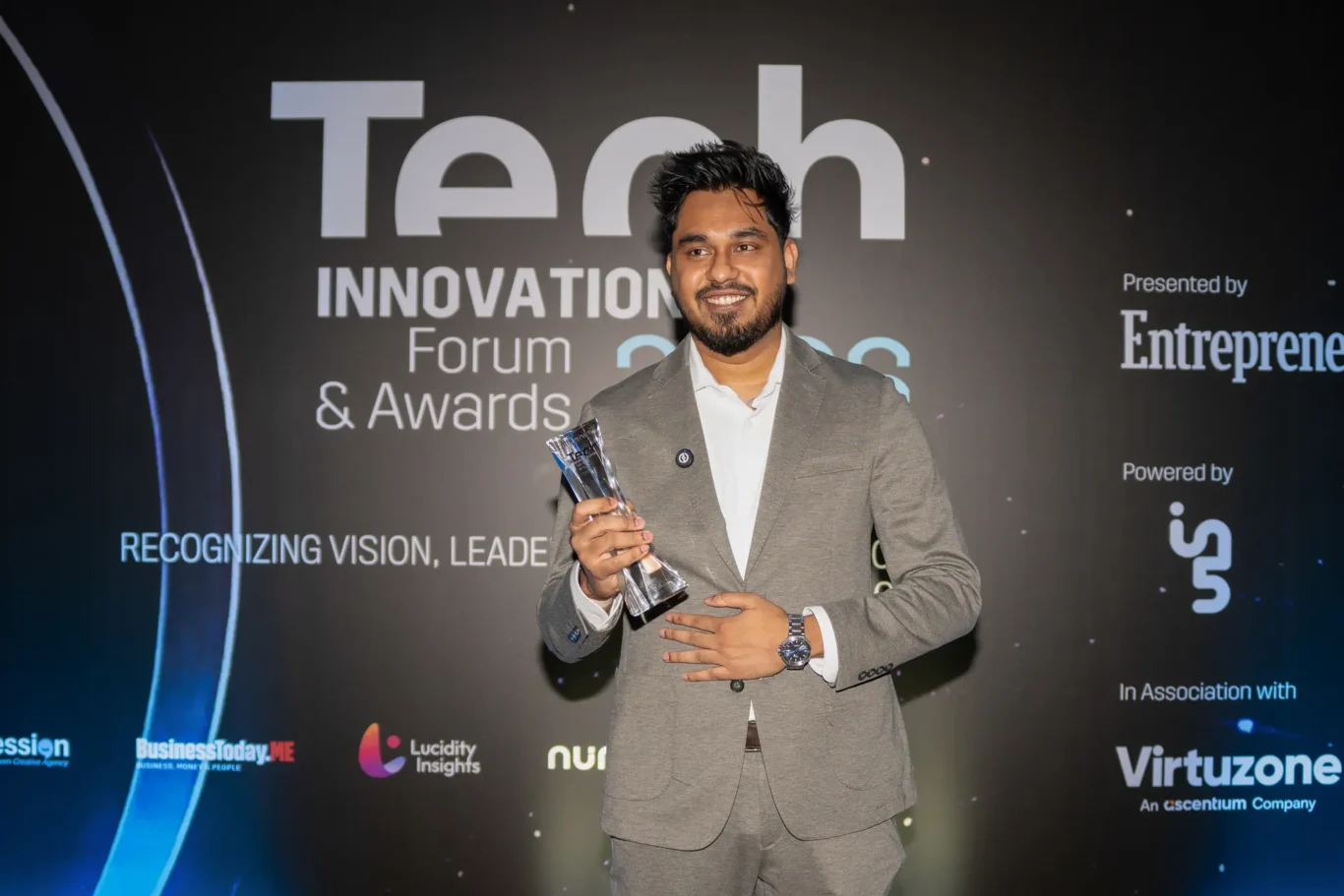 Award winner holding the trophy at the awards backdrop. Event photography by MRPS for FundedNext at the Tech Innovation Awards 2026, Al Habtoor Palace, Dubai.