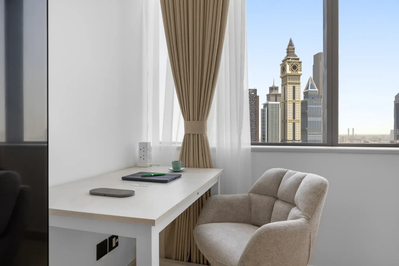 Work desk and armchair beside the window in a Your Stay Apartments one-bedroom at Sky Gardens, DIFC, Dubai.
