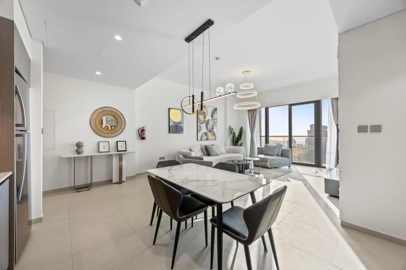 Marble dining table with black chairs under pendant lights. Airbnb photography by MRPS for Solea Stay in Dubai.