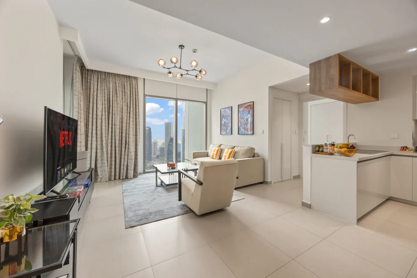 Living room with sofa, wall art and glass door to the balcony. Day, twilight and night Airbnb photography by MRPS for Vista Haus Holiday Homes in Downtown Dubai.