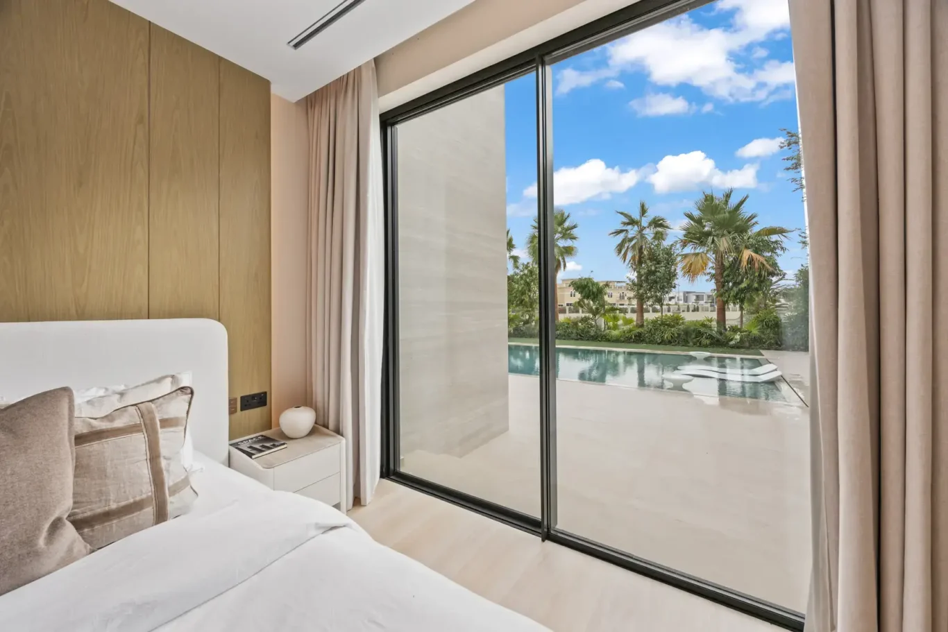 Bedroom sliding doors opening onto the pool and garden, luxury villa in Jumeirah Islands, Dubai.