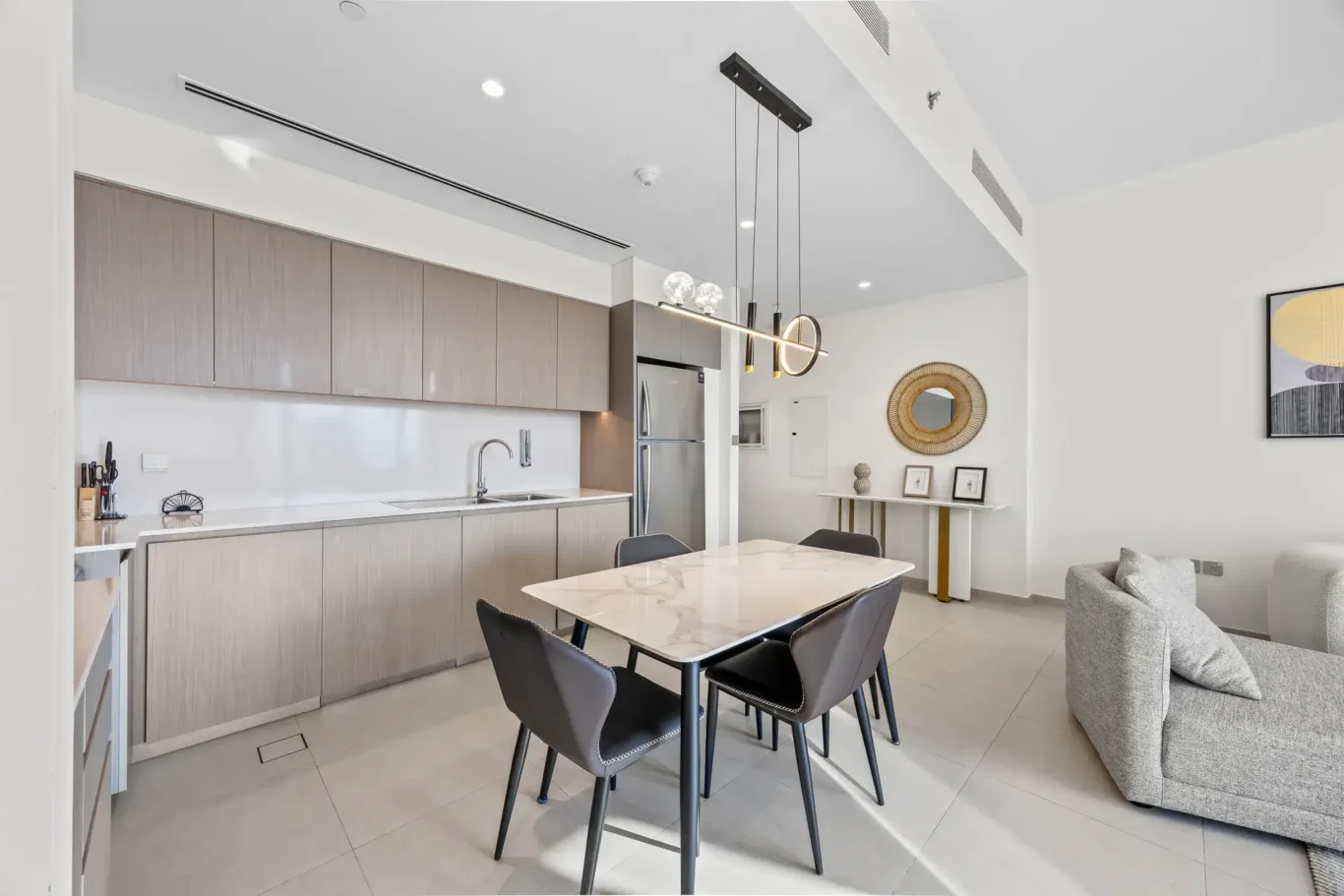 Dining area beside the modern kitchen with wall art. Airbnb photography by MRPS for Solea Stay in Dubai.