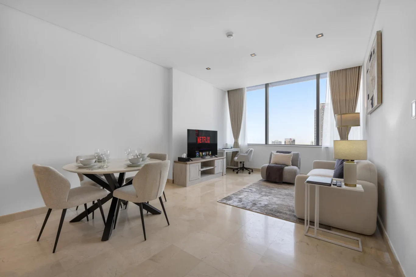 Dining table and lounge area in a Your Stay Apartments one-bedroom at Sky Gardens, DIFC, Dubai.