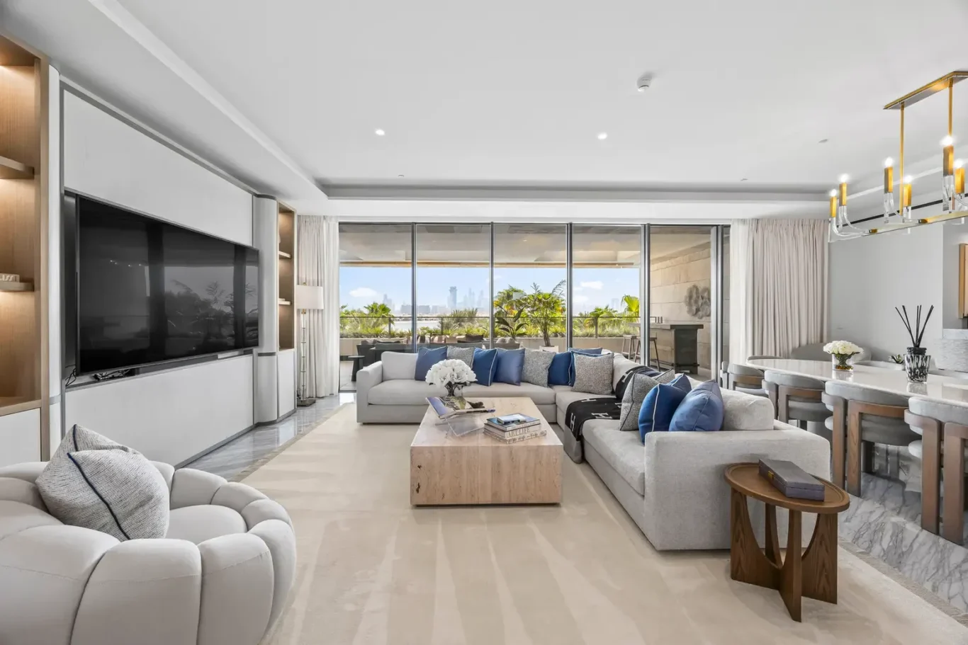 Living room with large sofas and full-height windows to the terrace in a furnished three-bedroom residence at Atlantis The Royal, Palm Jumeirah, photographed for Apex Homes Real Estate.
