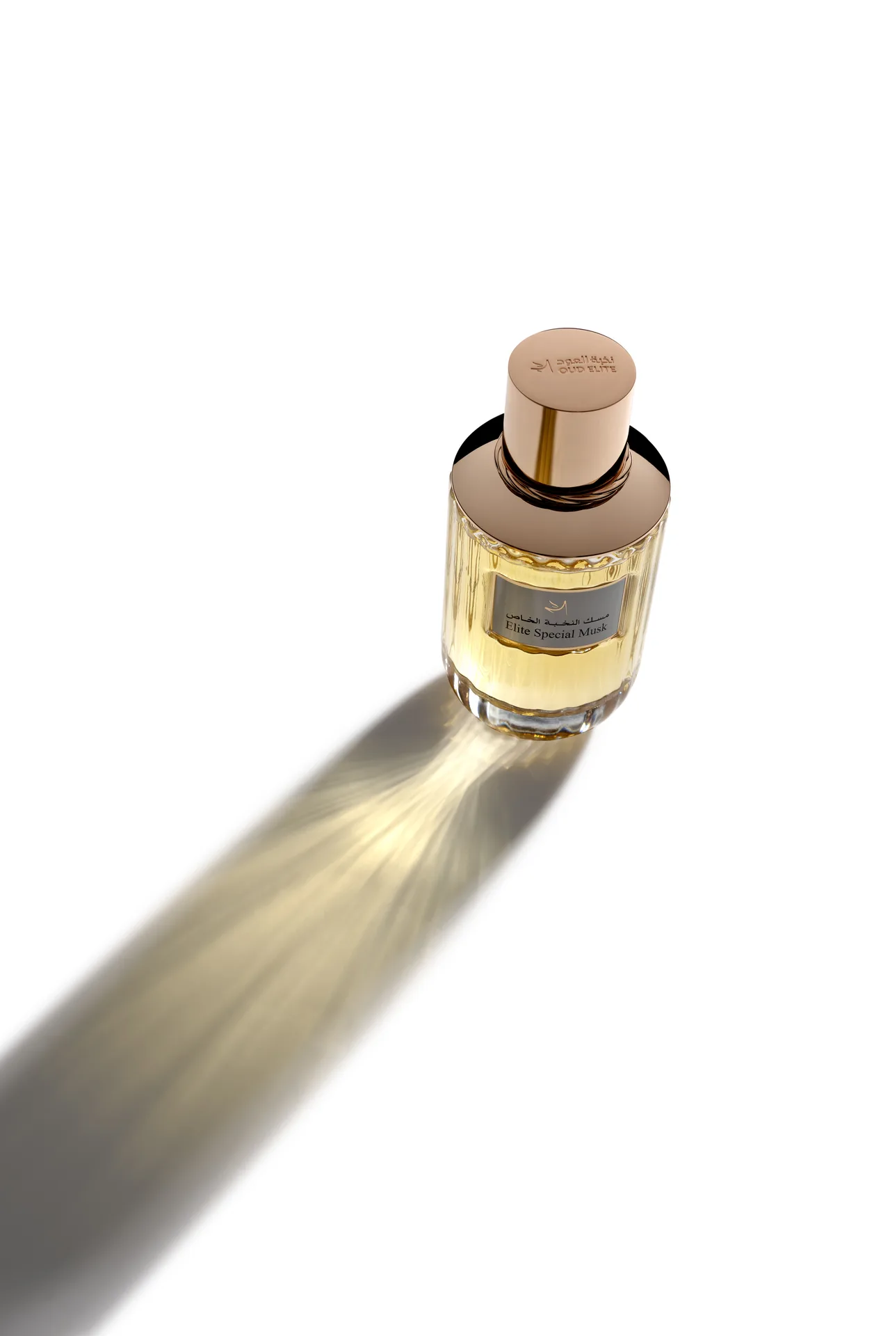 High-angle shot of the Oud Elite Special Musk perfume bottle with light passing through the golden fragrance.