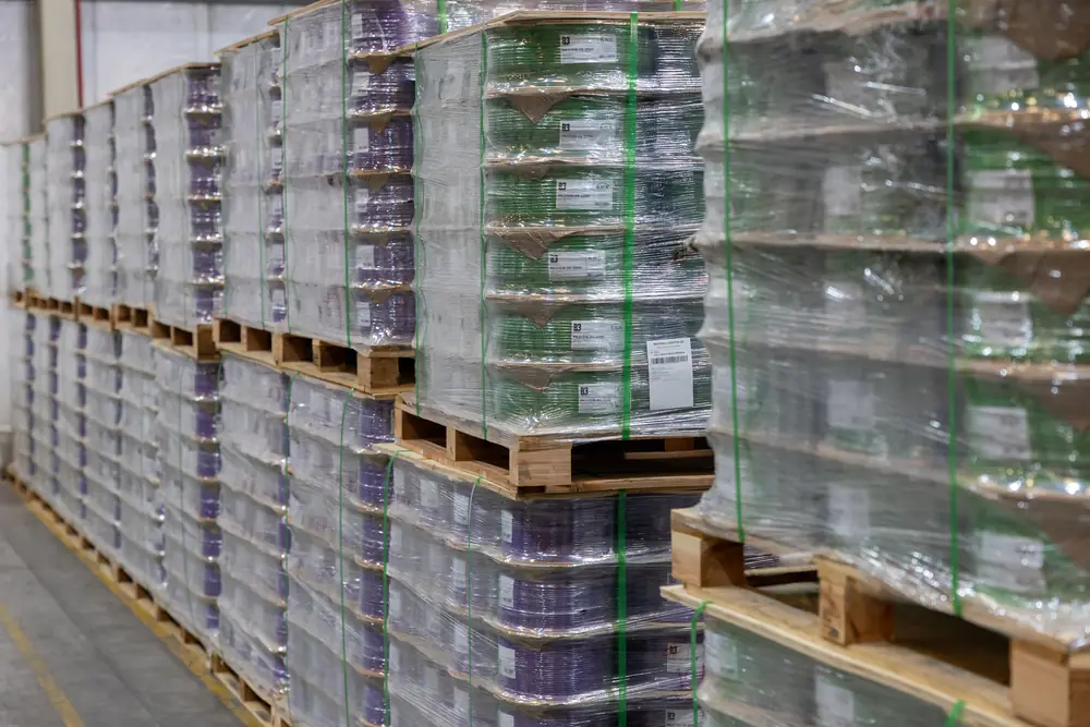 Rows of labelled cable reel pallets stacked two high in the B3 International distribution warehouse, Dubai.