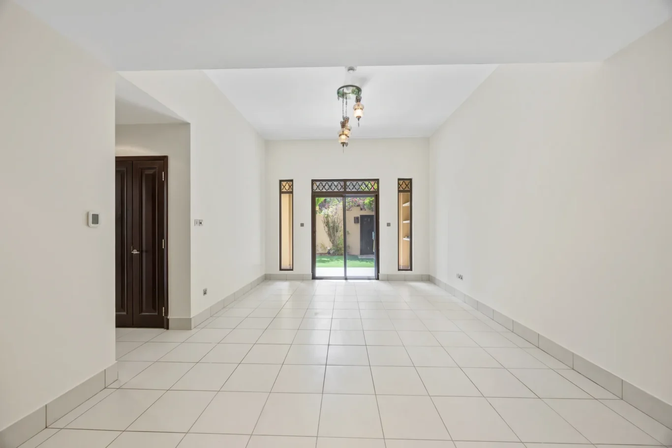 Living room overview with garden-facing windows in an unfurnished two-bedroom garden apartment in Old Town, Downtown Dubai, photographed for ELITE Property Brokerage.