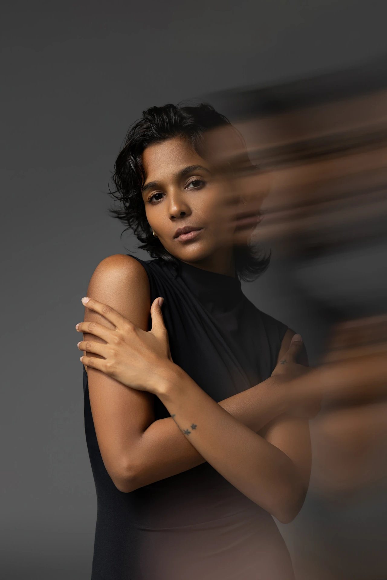 Creative portrait of Mia in a black sleeveless dress with motion blur across the frame.