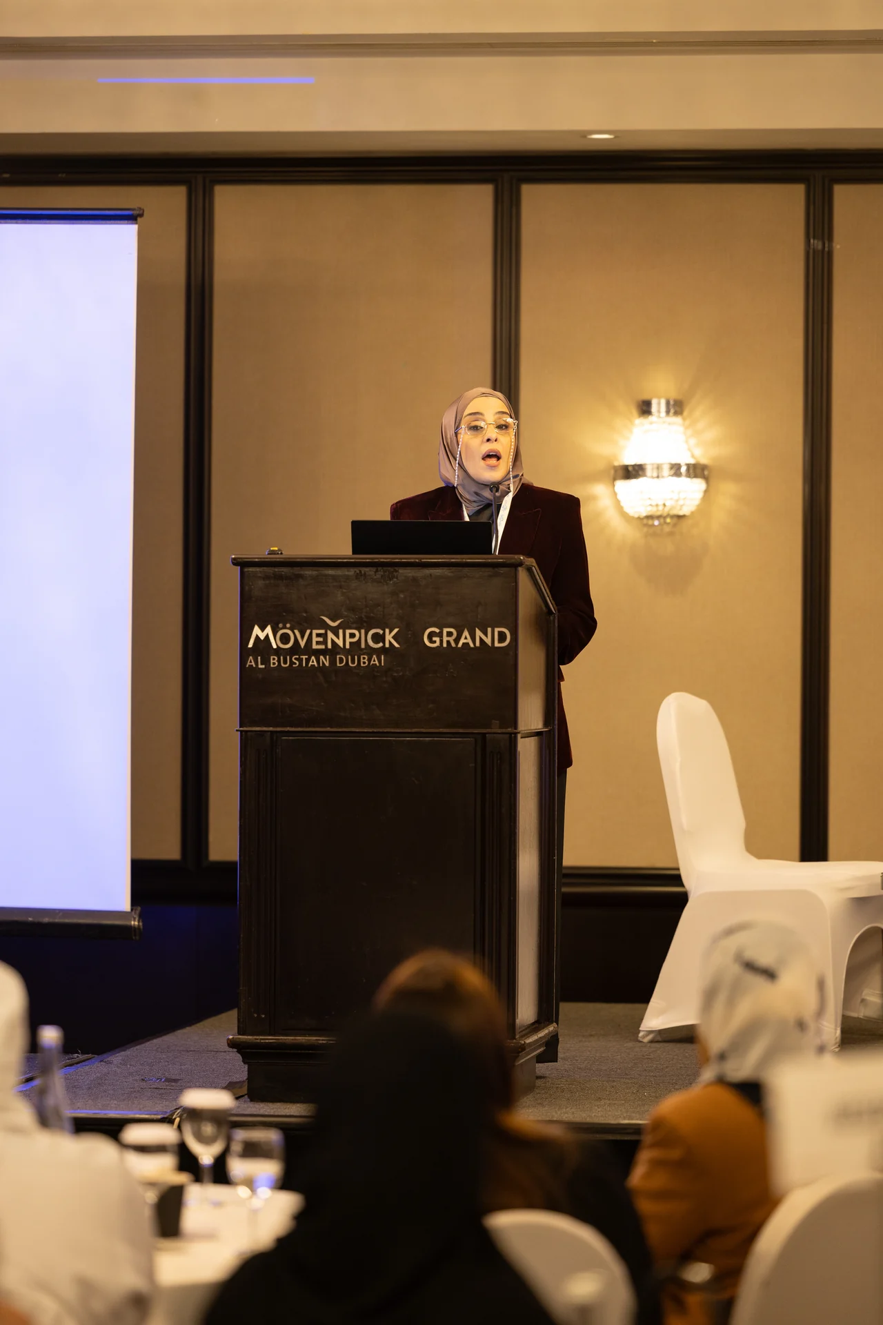 Wide view of a speaker at the podium in the ballroom. Corporate event photography by MRPS for My Arabic Publishing at Movenpick Grand Al Bustan, Dubai.