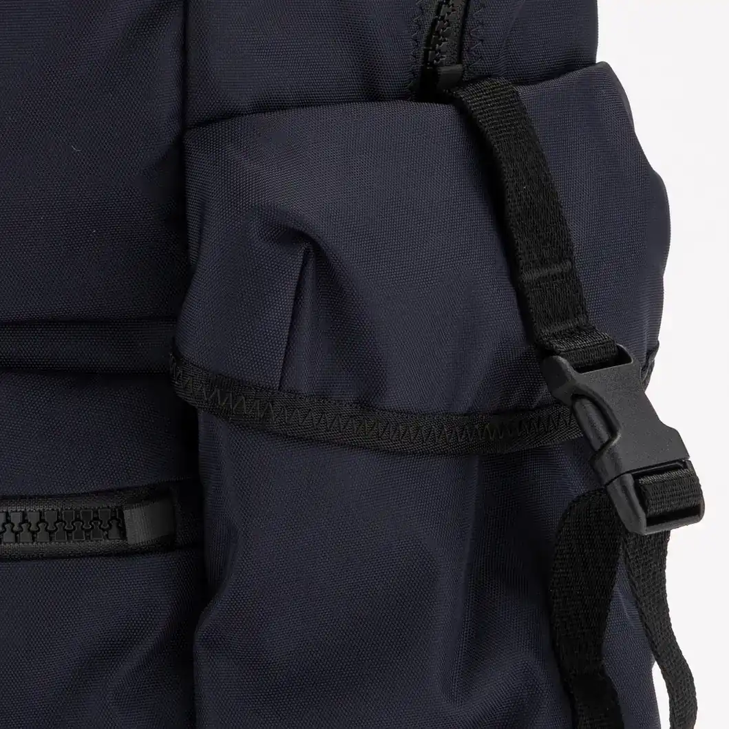 Close-up of the side pocket and buckle on the navy New Balance backpack. E-commerce product photography for New Balance by MRPS in Dubai.