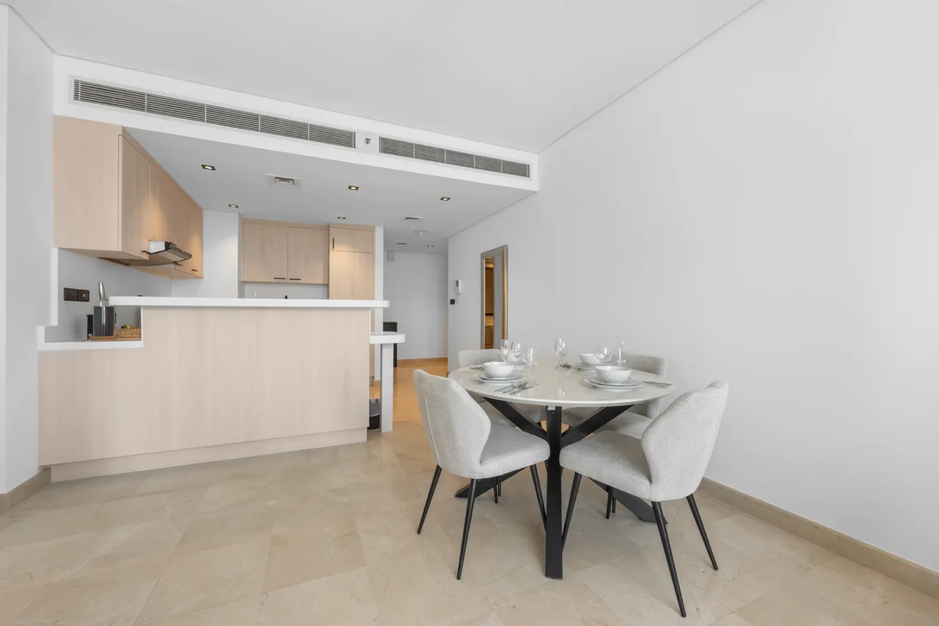 Dining table for four by the kitchen in a Your Stay Apartments one-bedroom at Sky Gardens, DIFC, Dubai.