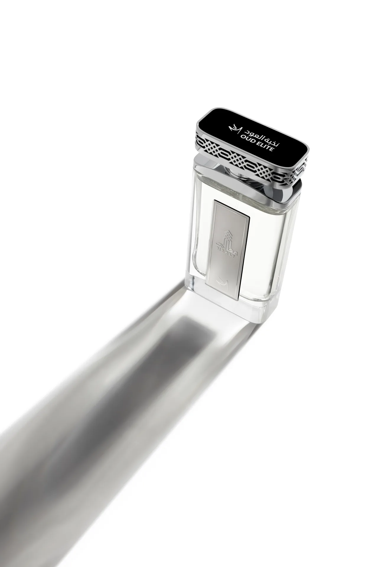 High-angle shot of the Oud Elite Maaly perfume bottle with the Oud Elite logo on its silver cap and a long grey shadow.