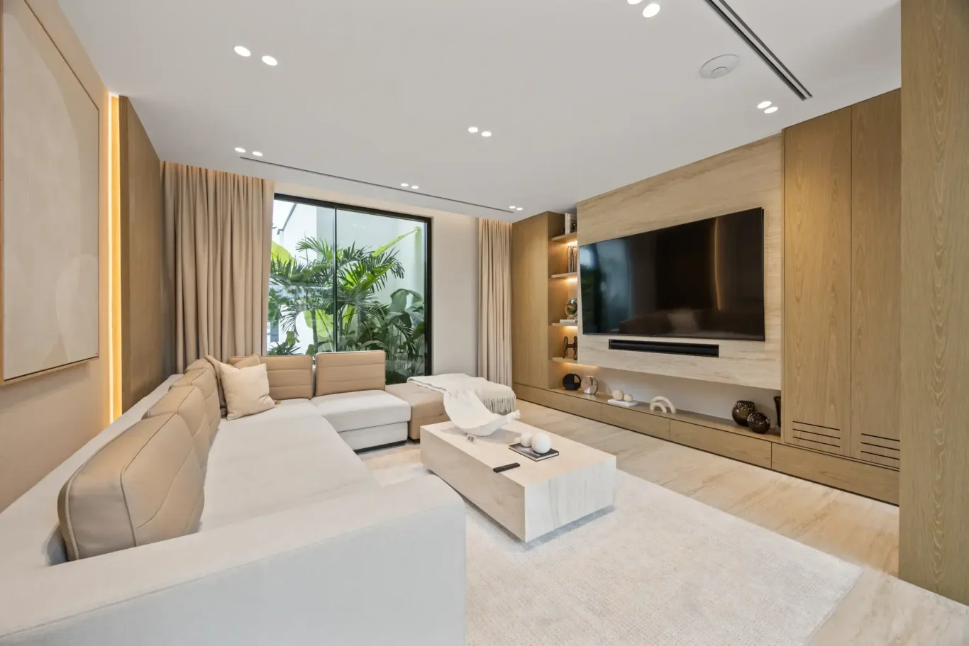 Family TV lounge with a corner sofa and media wall, luxury villa in Jumeirah Islands, Dubai.
