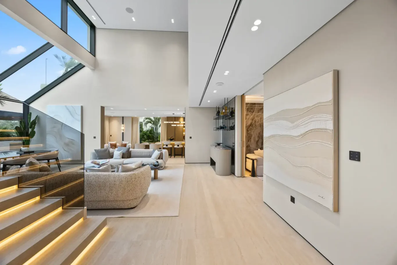 Living room seen from the stairs under a glass skylight, luxury villa in Jumeirah Islands, Dubai.